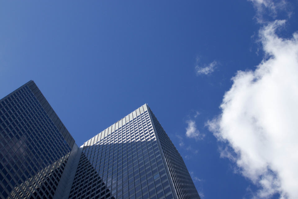 Glass office tower against a blue sky